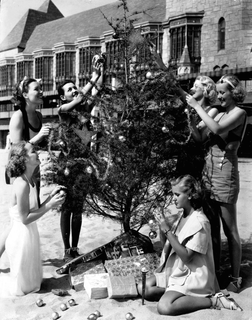 Volume 2, Page 109, Picture 8, A group of women decorating a christmas tree on the beach, circa 1950 (Photo by Popperfoto/Getty Images)
